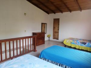 1 dormitorio con 2 camas y barandilla de madera en Casa Bony, en Montañita
