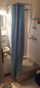 La salle de bains est pourvue d'une douche avec un rideau de douche bleu. dans l'établissement Adikati Lak, à Bük