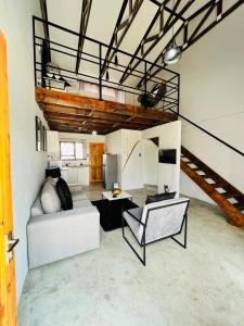 a living room with a white couch and a staircase at Kates Nest Guesthouse Oshakati in Oshakati