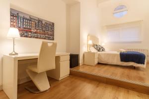 sypialnia z łóżkiem, biurkiem i stołem w obiekcie Konporte, Vivienda Turística Renovada con Wifi y Garaje w mieście Getxo