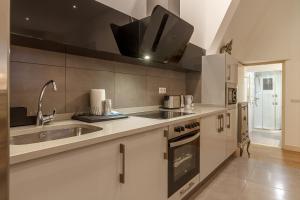 duża kuchnia ze zlewem i kuchenką w obiekcie Konporte, Vivienda Turística Renovada con Wifi y Garaje w mieście Getxo