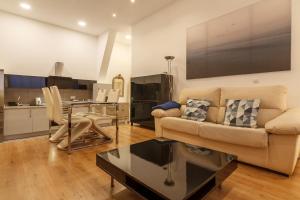 een woonkamer met een bank en een tafel bij Konporte Apartamento Renovado con Wifi y Garaje in Getxo