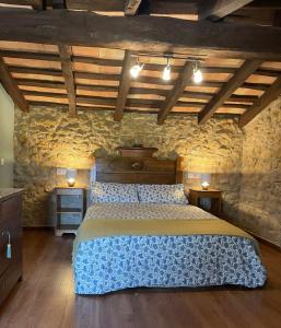 Un dormitorio con una cama grande en una pared de piedra. en Mas Feliu Turismo Rural, en Pujals dels Cavallers