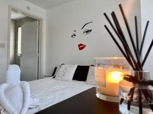 a bedroom with a bed and a candle on a table at 3 Bedrooms House in Manchester in Manchester