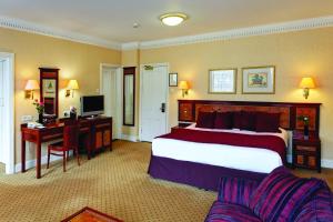 a hotel room with a bed and a desk and a computer at Grange Portland Hotel in London