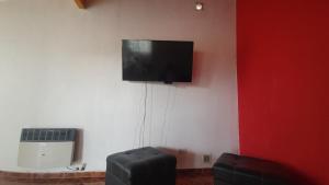 Habitación con TV de pantalla plana en la pared en Departamento Asaï Malargüe en Malargüe