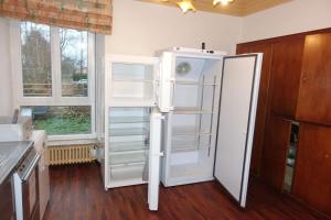 un frigorifero bianco in una cucina accanto a una finestra di VILLA 50 personnes avec piscine et terrain de tennis et Basket a Diemeringen