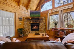 a living room with a fireplace in a log cabin at Rustic Retreat in Sevierville