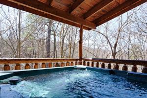 a hot tub on a porch with a wooden roof at Rustic Retreat in Sevierville