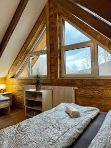 um quarto com 2 janelas e uma cama grande em Cichosza domek w Szczyrku em Szczyrk