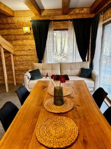 uma mesa de madeira com flores numa sala de estar em Cichosza domek w Szczyrku em Szczyrk