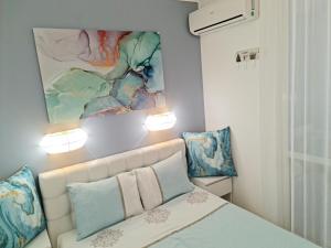 a bedroom with a bed with two pillows and a painting at GH Apartment Admiral Sveti Vlas in Sveti Vlas