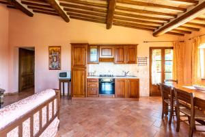 a large kitchen with wooden cabinets and a table at Agriturismo S. Eurosia in Montalcino