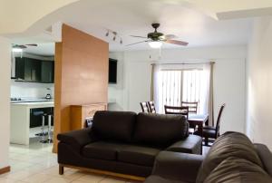 een woonkamer met een bank en een keuken bij Alojamiento completo 3 habitaciones (se puede facturar) in Chihuahua