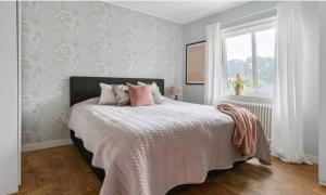 a bedroom with a bed with pink pillows and a window at Cheerful Three room villa at Strömstad City Center in Strömstad