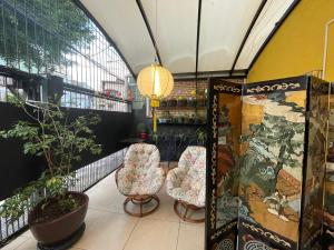 a room with two chairs and a table and some plants at Hostel Ipê in Sao Paulo