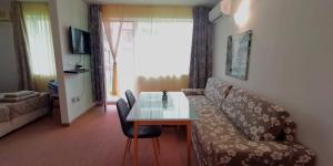 uma sala de estar com um sofá e uma mesa em Seaview apartment - Clara Sarafovo - 100m to sea em Burgas