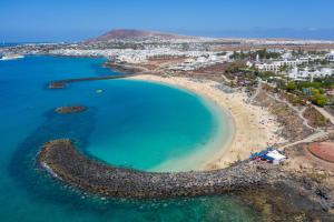 una vista aerea di una spiaggia con acqua blu di Villa Abuelo Paco a Playa Blanca