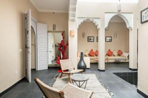 sala de estar con 2 sillas y sofá en Riad l'Empire, en Marrakech