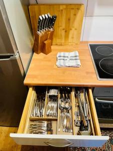 a wooden drawer filled with utensils on a counter at Zauberhaftes Vierbett-Apartment nahe Magdeburg in Barleben