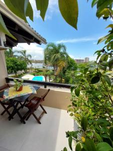 a balcony with a table and a view of the ocean at Pousada Brisas do Rio in Torres