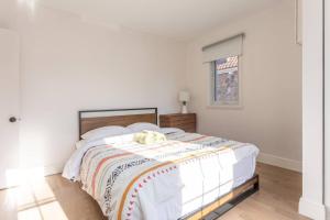 ein weißes Schlafzimmer mit einem Bett mit einer Decke darauf in der Unterkunft Free Parking, Beautiful 4 1/2-2 BR apartment in Montreal