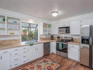 a kitchen with white cabinets and stainless steel appliances at Experience Nirvana with artwork collections from around the globe Located in Lakewood neighborhood in SE Boise next to a park, Minutes from Bown Crossing and the Boise River, 10 minutes to downtown, 4 beds, sleeps 8, pets welcome in large fenced in yard in Boise