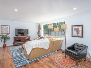 un soggiorno con divano e sedia di Experience Nirvana with artwork collections from around the globe Located in Lakewood neighborhood in SE Boise next to a park, Minutes from Bown Crossing and the Boise River, 10 minutes to downtown, 4 beds, sleeps 8, pets welcome in large fenced in yard a Boise