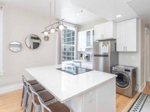 a kitchen with white cabinets and a white counter top at Downtown Digs-View of the City! Stay above local restaurants and nightlife, posh amenities heated toilet seat, oversized rain shower head in glass shower, in-unit laundry, one garage parking spot in Boise