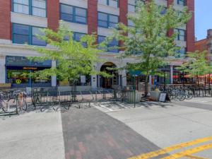 a building with chairs and trees in front of a building at Downtown Digs-View of the City! Stay above local restaurants and nightlife, posh amenities heated toilet seat, oversized rain shower head in glass shower, in-unit laundry, one garage parking spot in Boise