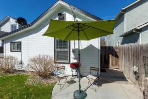 - un parasol vert dans la cour d'une maison dans l'établissement Red Bench Cottage Ideal location near parks, trails, skiing, hiking, biking, shopping extended stays welcome, à Boise