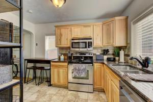 a kitchen with wooden cabinets and a stove top oven at Home Sweet Idahome, feels like home with all the decor you wish you could afford King bed in master, fully fenced dog friendly yard, a few blocks from BSU and downtown Boise, Your perfect stay! in Boise