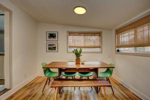 uma sala de jantar com uma mesa de madeira e cadeiras verdes em Sunset Home perfect for extended stays with fully fenced in yard, designated office, two living rooms, located across from Boise Foothills and close to Bogus Basin in Boise's North End em Boise