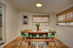 a dining room with a wooden table and green chairs at Sunset Home perfect for extended stays with fully fenced in yard, designated office, two living rooms, located across from Boise Foothills and close to Bogus Basin in Boise's North End in Boise