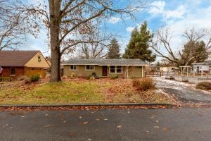a house with a tree on the side of a street at Sunset Home perfect for extended stays with fully fenced in yard, designated office, two living rooms, located across from Boise Foothills and close to Bogus Basin in Boise's North End in Boise