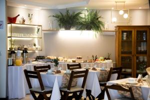uma sala de jantar com mesas e cadeiras brancas em Pousada Brisas do Rio em Torres