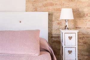 une lampe sur une table de nuit à côté d'un lit dans l'établissement B&B Casa Fanny Riviera Del Conero, à Loreto