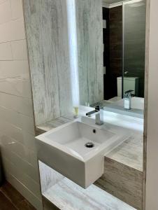 uma casa de banho com um lavatório branco e um espelho. em Banana Hotel Motel em Banana