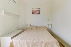 um pequeno quarto com uma cama num quarto em Cobertura duplex c/piscina privativa,Praia Enseada no Guarujá