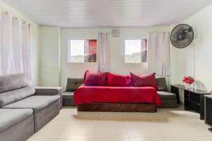 uma sala de estar com um sofá e um cobertor vermelho em Cobertura duplex c/piscina privativa,Praia Enseada no Guarujá