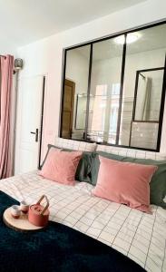 a bed with pink pillows and a tray on it at Joli Appartement à 15min des Champs Elysée in Saint-Ouen