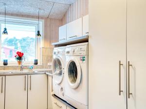 eine Küche mit Waschmaschine und Spüle in der Unterkunft 10 person holiday home in Fårevejle-By Traum in Fårevejle