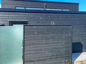a black building with a door in front of it at 10 person holiday home in Asn s in Asnæs