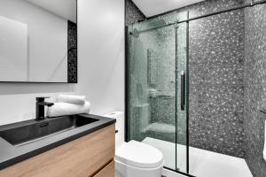 a bathroom with a shower and a toilet and a sink at Deluxe Suites Downtown Montreal in Montreal