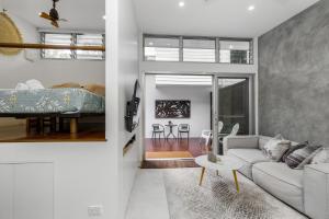 a living room with a couch and a bed at Studio 9 in Byron Bay
