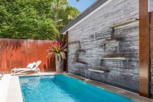 una piscina frente a una pared de ladrillo en Studio 9, en Byron Bay