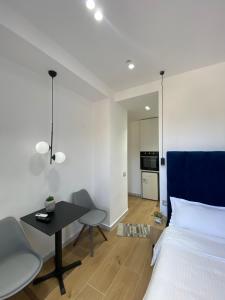 a bedroom with a bed and a table and a kitchen at Luxury Apartament in Blloku in front of Taiwan in Tirana