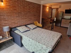 a bedroom with a bed against a brick wall at Shikoa Sobole - Le Morpho et l'Ara in Montjoly