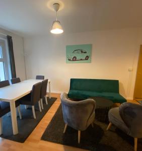 a dining room with a table and chairs and a green couch at Osthafen III in Berlin