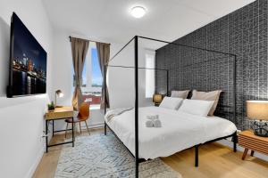 a bedroom with a large white bed and a desk at Deluxe Suites Downtown Montreal in Montreal